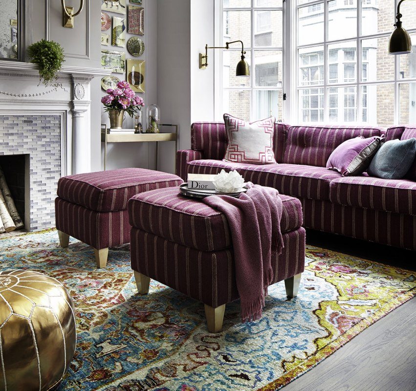 A set of a sofa and two blueberry poufs is a bright accent in the hall