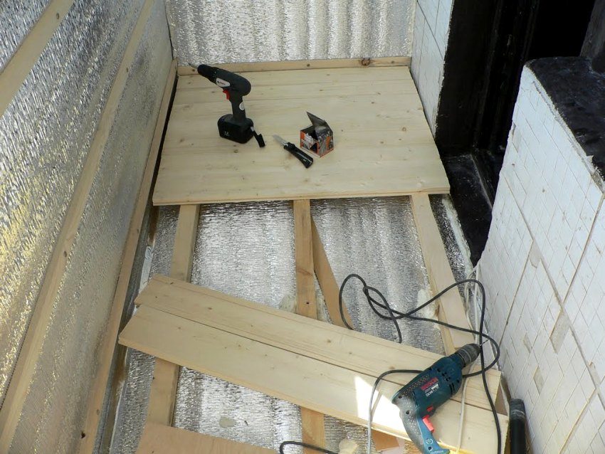 Anordnung des Bodens auf dem Balkon mit Holzstämmen und Brettern