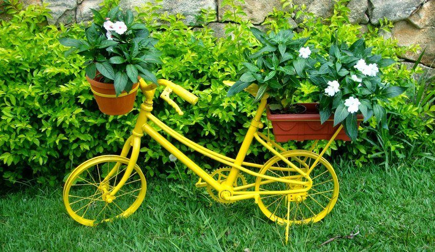 Un vieux vélo, peint dans une couleur vive, est une excellente option pour aménager un jardin fleuri