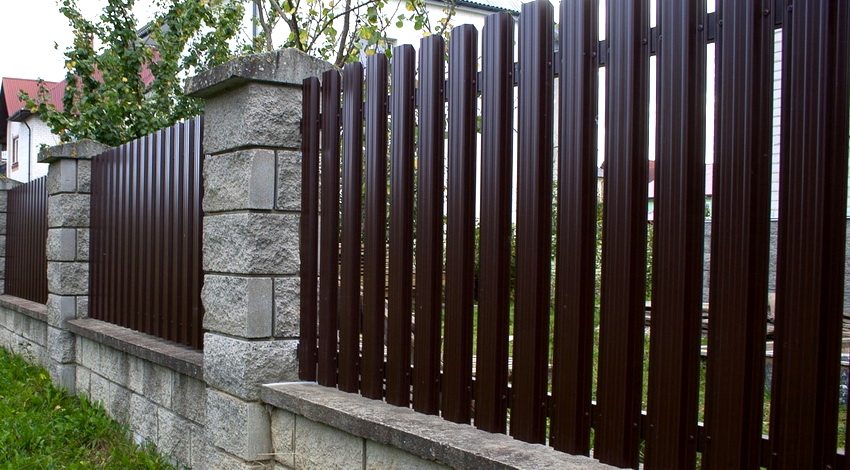 Primjer jednostavne i moderne ograde stranice izrađene od euro štaketnika s kamenim nosačima