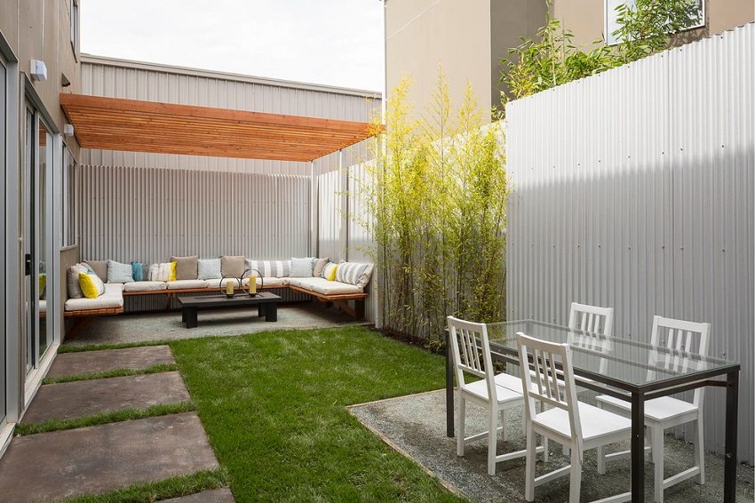 A high fence made of metal profiles will create a cozy atmosphere in the yard
