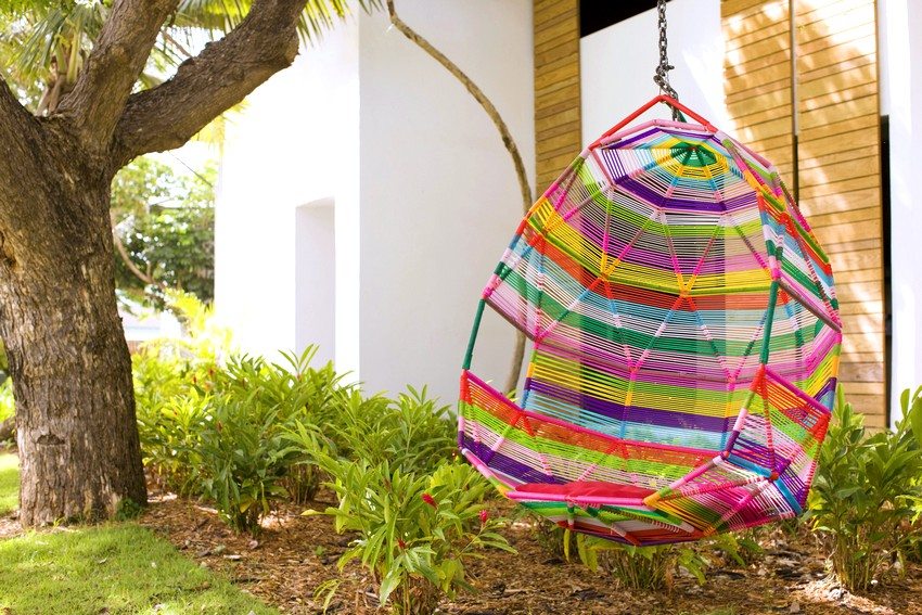 Bright cocoon swing suspended from a tree branch