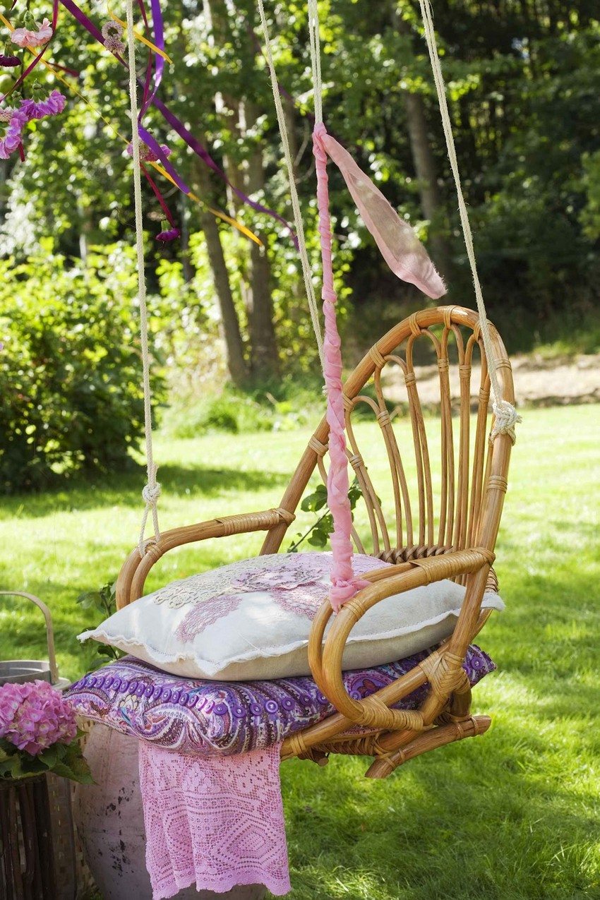 Hanging swing from a wicker chair decorated with bright ribbons