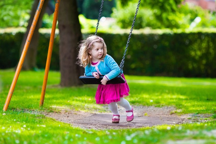 Children's swing suspended from the frame on chains