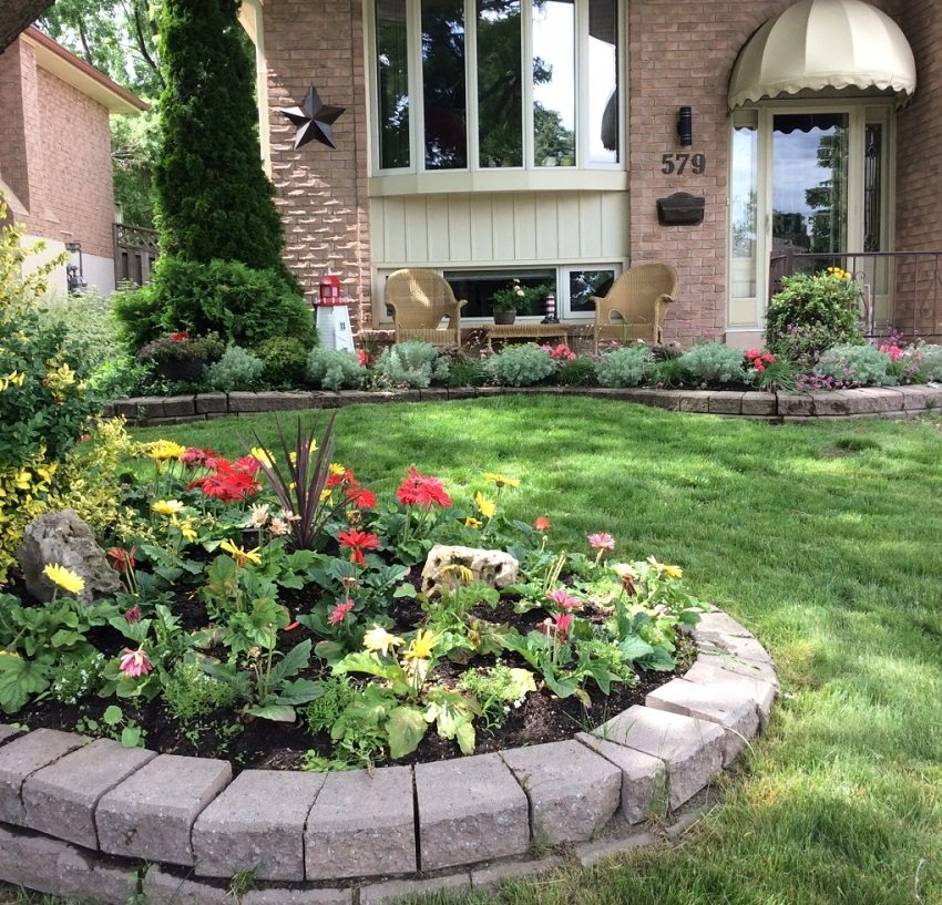 A flowerbed with a brick border decorates the yard