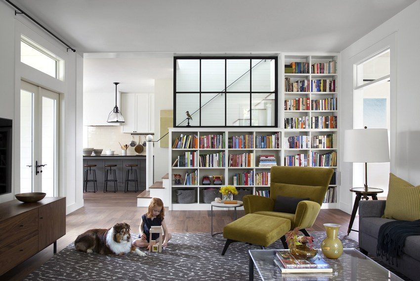 Partition in the form of a bookcase that separates the living room from the stairs to the second floor