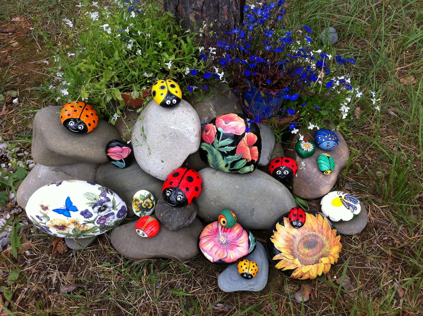 Paturile de flori în combinație cu pietrele arată foarte impresionant în grădină